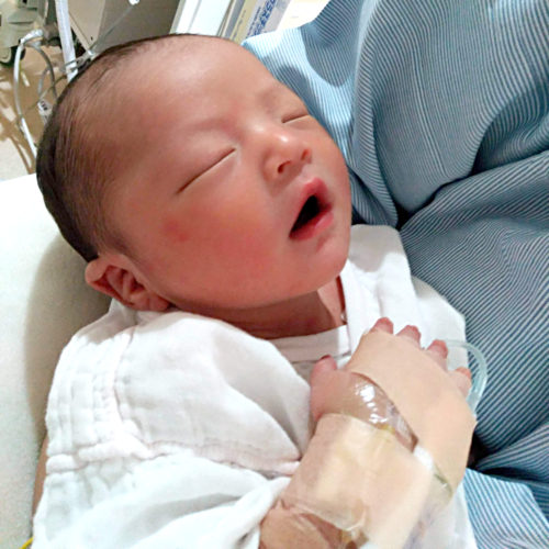 NICUでお母さんに抱かれ寝ている赤ちゃん